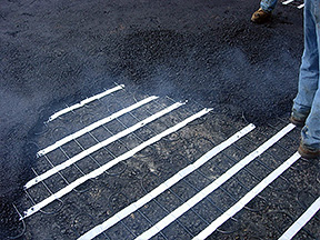 Snow melting mats with hot asphalt being applied