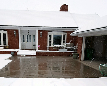 A heated driveway system in concrete operating during a snowstorm.