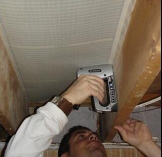 Man nailing retroheat into underfloor joists