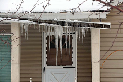 Home with damaged gutters, in need of a roof de-icing system