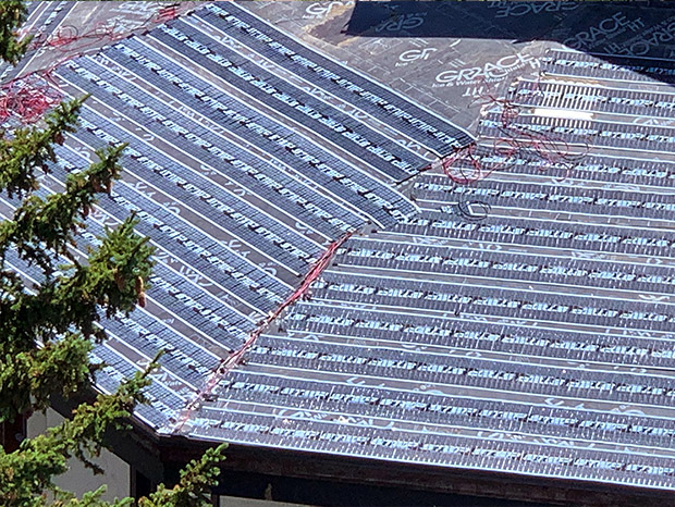Low-voltage roof heating system being installed on resort roof