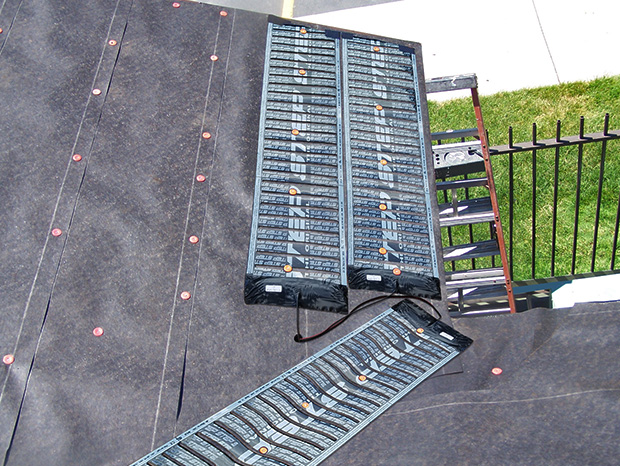 Low-voltage roof de-icing system being installed to heat eaves and roof valleys
