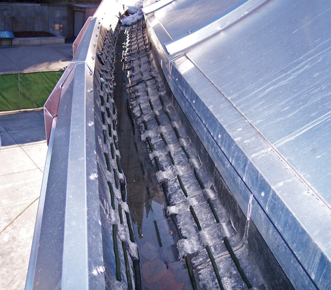 Self-regulating heat cable in roof gutters of a large commercial de-icing application