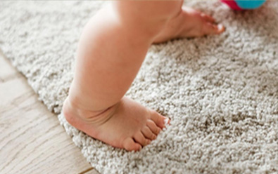 Baby's feet shown on carpet