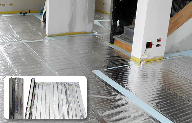 FoilHeat floor heating element being installed to heat basement floor