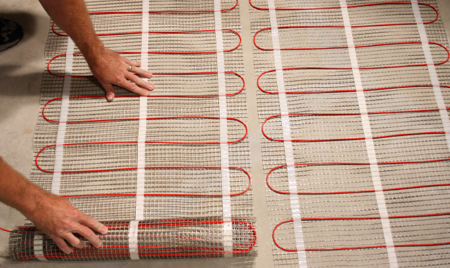 Installing floor heating mats to heat basement floor