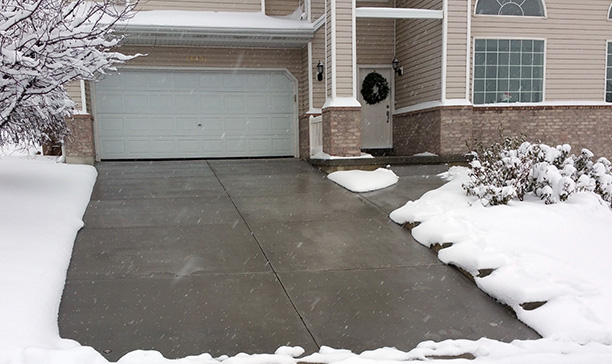 Snow melting system installed - heated tire tracks in asphalt driveway