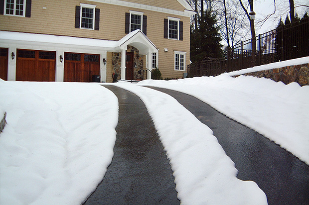 Heated asphalt tire tracks in driveway