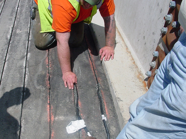 Snow melting heat cable being placed in saw-cut grooves