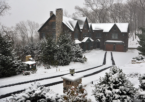 A heated driveway (heated tire tracks) leading up to a home in the country.